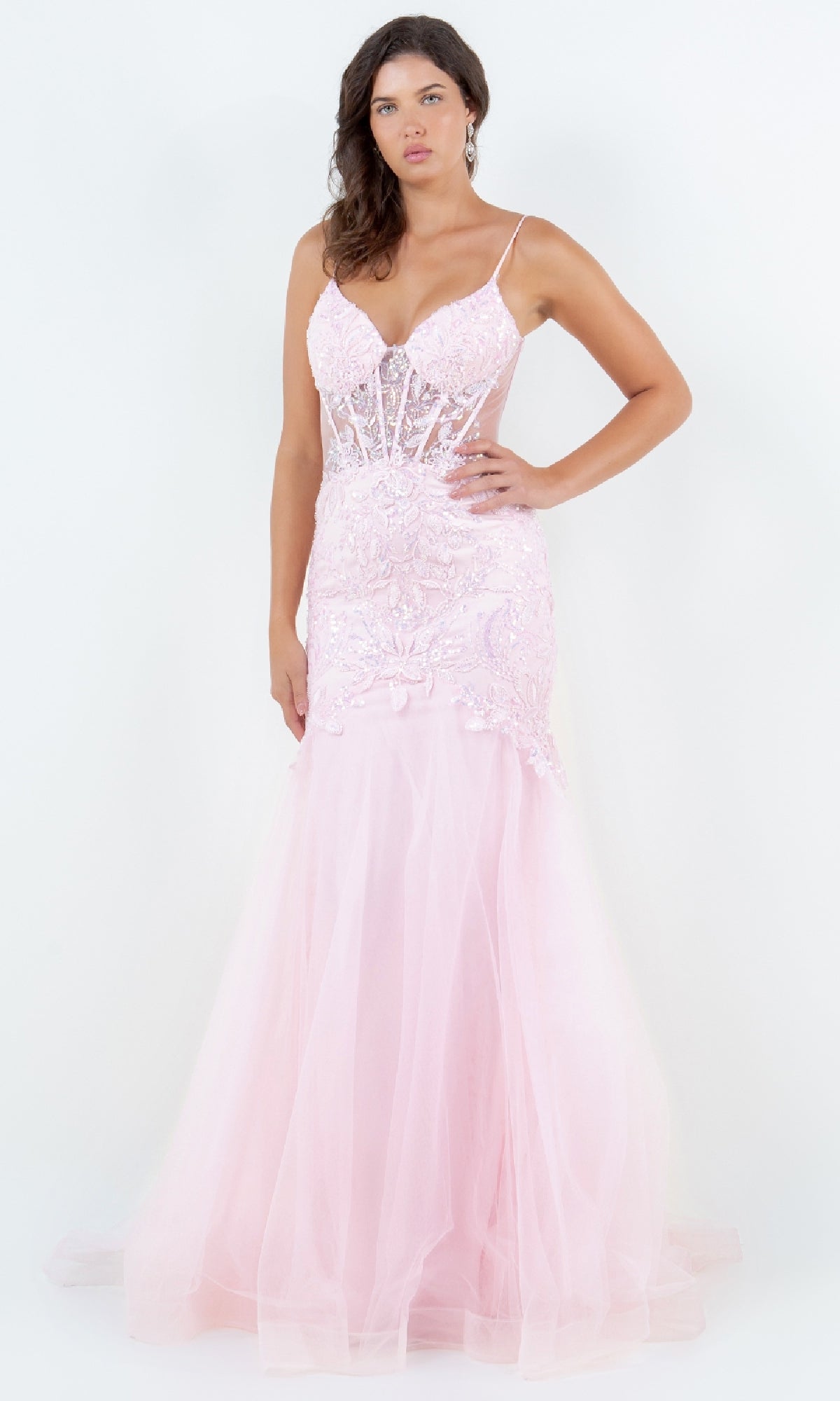 A woman models the Cinderella Couture 8276J, a light pink long mermaid prom dress with thin straps, lace details, and a sheer flared skirt, standing against a plain white background.